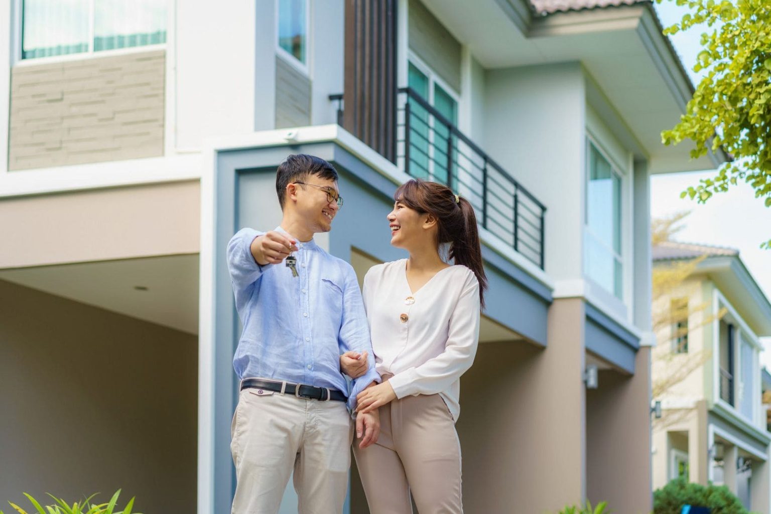 portrait-asian-young-couple-standing-hugging-together-holding-house-key-looking-happy-front-their-new-house-start-new-life-family-age-home-real-estate-people-concept