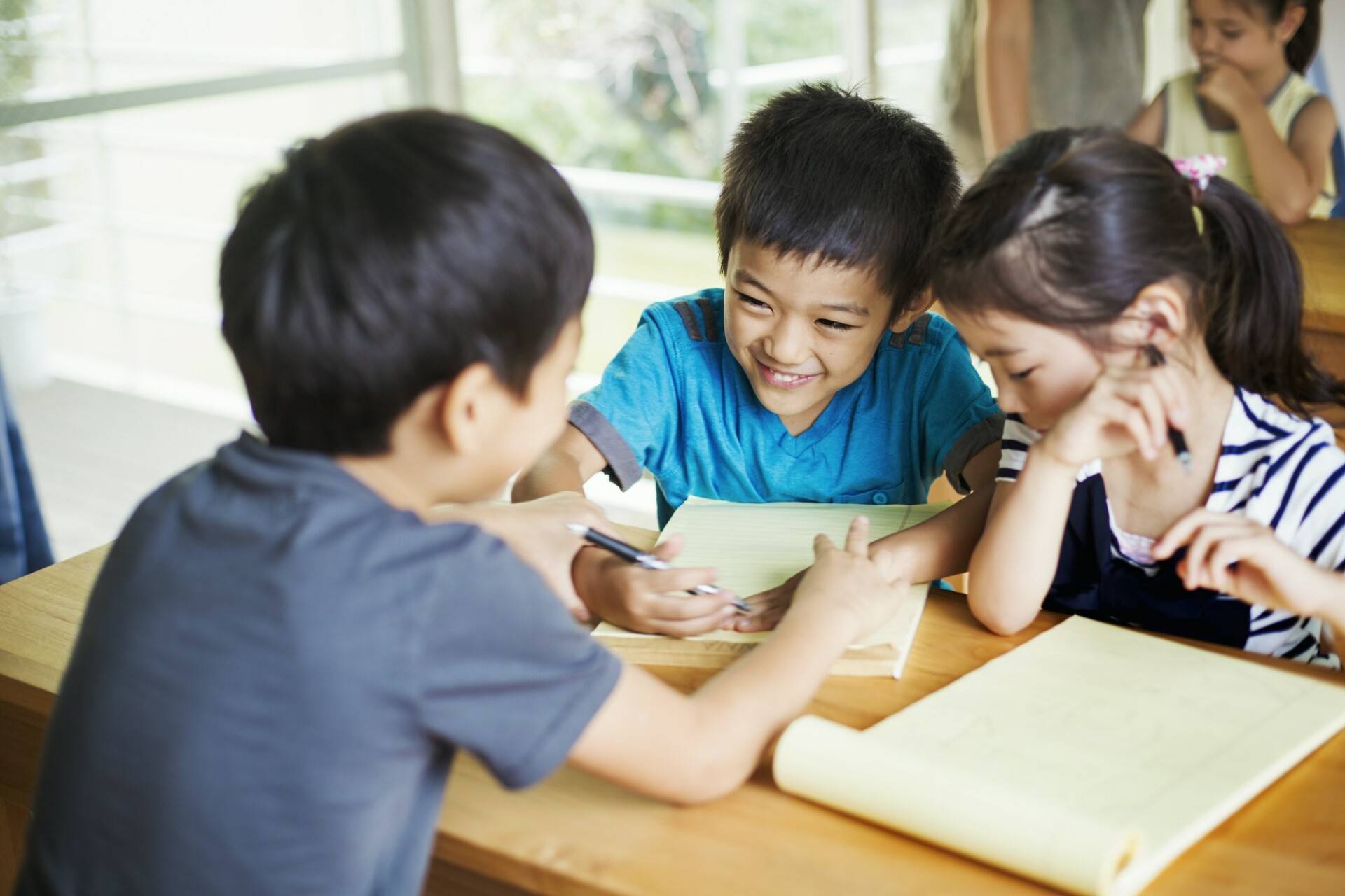A group of children in a classroom, working together, boys and girls.