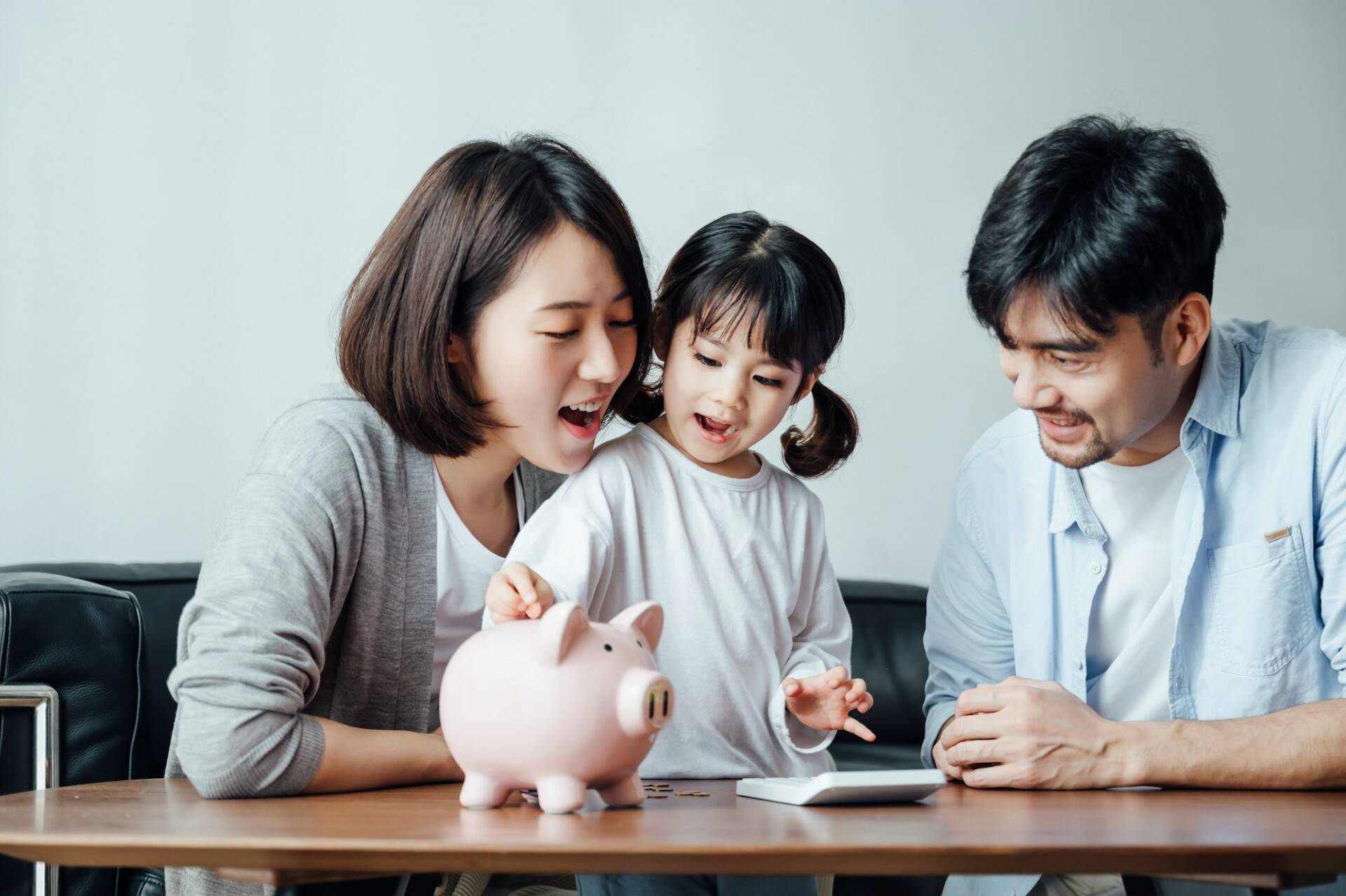 Parents teaching daughter to save money at home