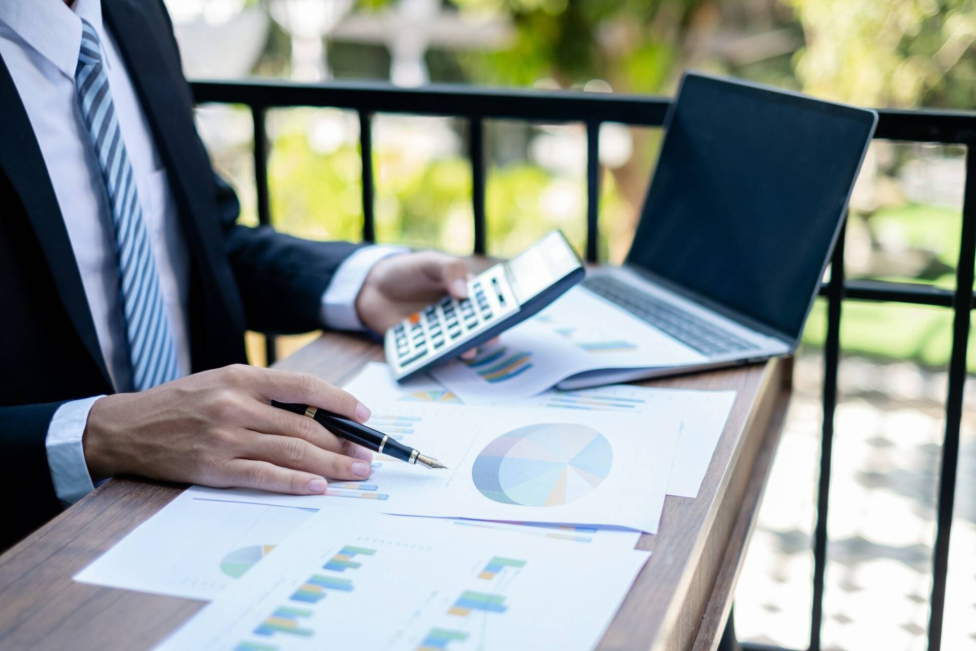 Young businessman financial market analyst sits at their desks and calculate financial graphs
